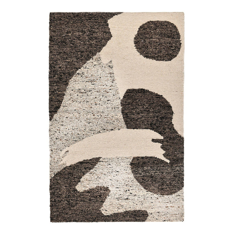 Patterned area rug with cream base and dark brown abstract forms and speckled detail.
