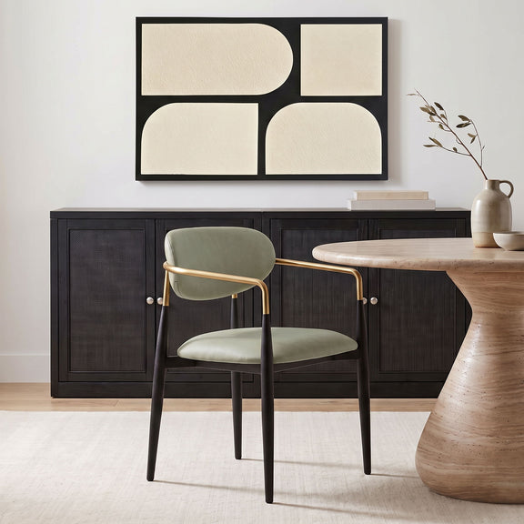 Upholstered dining arm chair with sage green seat, black legs, gold arm frame