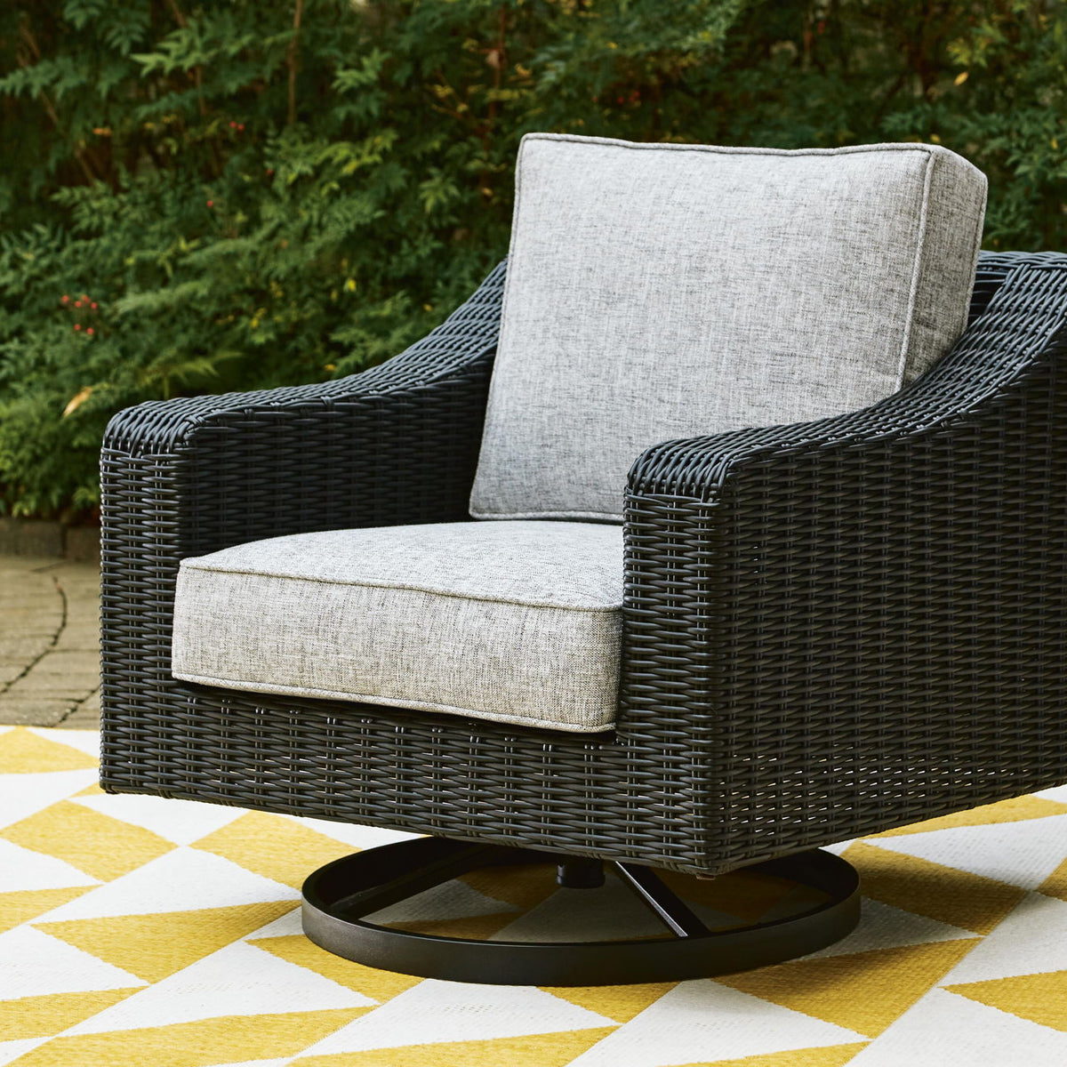 Black wicker swivel lounge chair with light gray seat cushion and upright backrest.