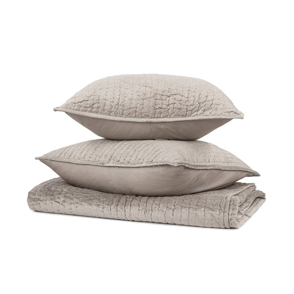 Light gray velvet pillow shams set with quilted covers, stacked for display
