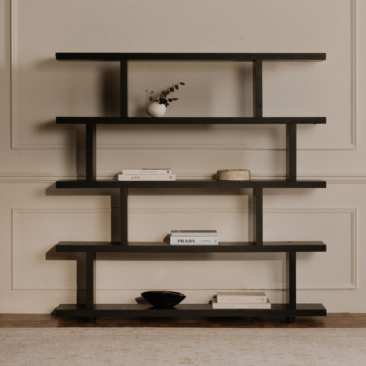 Large black five-tier shelf styled with books and decorative objects.