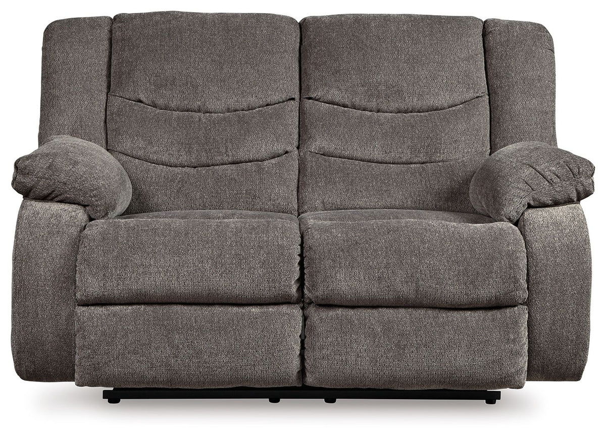 Gray reclining loveseat with padded arms and tufted back cushions, front view