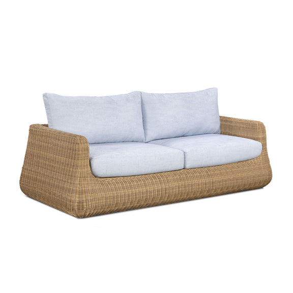 Outdoor sofa with light blue cushions on brown woven wicker base