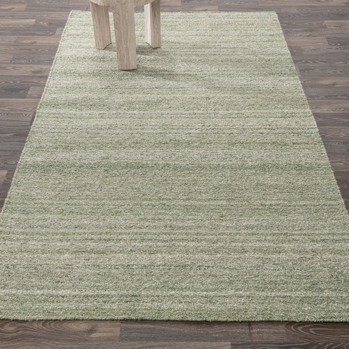 Large sage green textured area rug with horizontal stripes under table