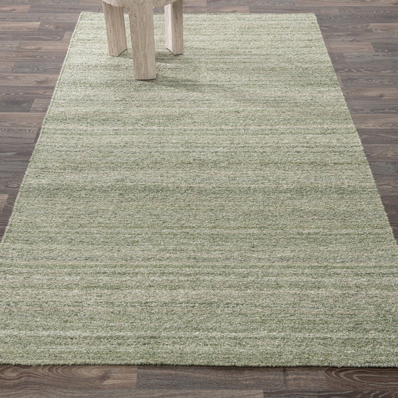 Large sage green textured area rug with horizontal stripes under table