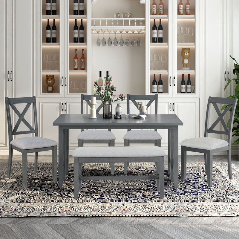 Gray dining table with four cross-back chairs and upholstered bench seating set
