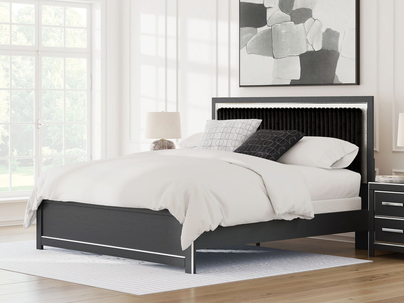 Upholstered panel bed with dark frame and upholstered headboard, shown with pillows and duvet.