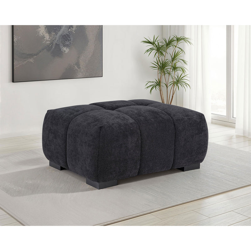 Dark gray rectangular upholstered ottoman with rounded corner legs and tufted panels.