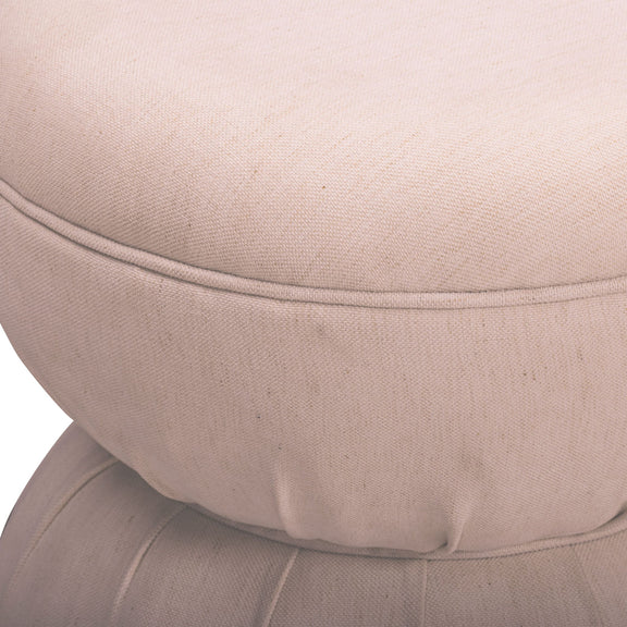Close-up of light pink-beige ruched upholstered ottoman with stitched seam