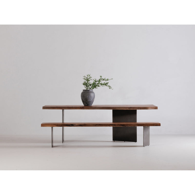 Dining table with natural wood top and dark metal supports, side view