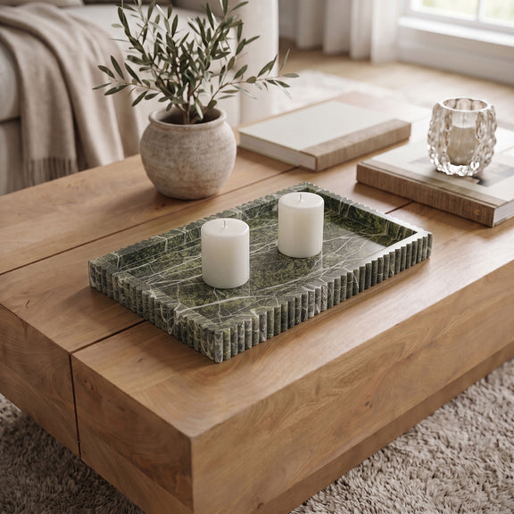 Dark green marble tray with ridged sides holding three white pillar candles