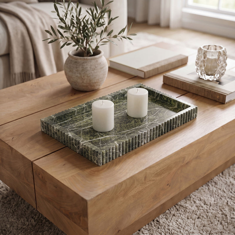 Dark green marble tray with ridged sides holding three white pillar candles