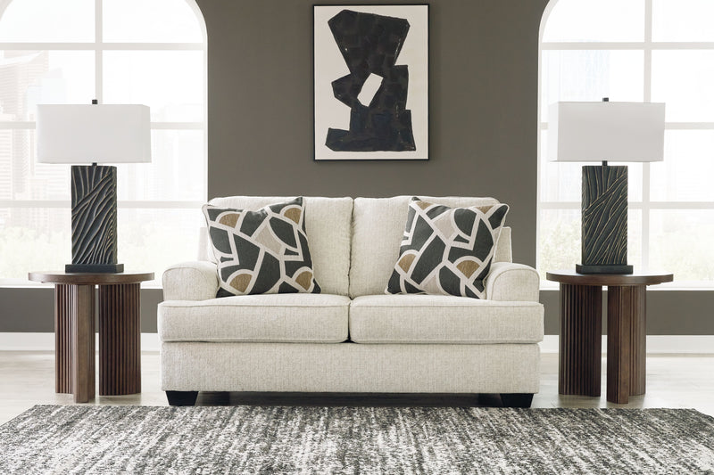 Beige loveseat with two geometric black-and-cream accent pillows and squared arms