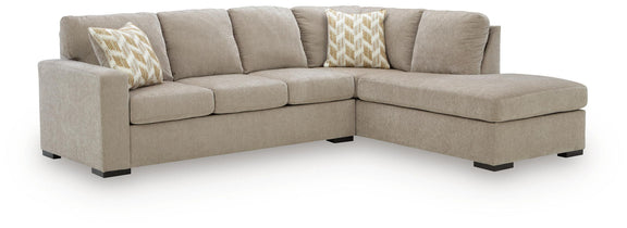 Sleeper sectional sofa with corner chaise, taupe upholstery, two patterned accent pillows