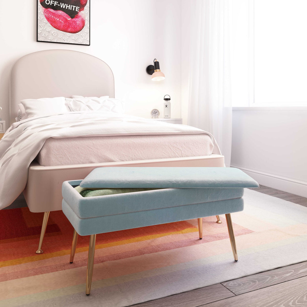 Light blue velvet storage bench in a bedroom setting with tapered gold legs