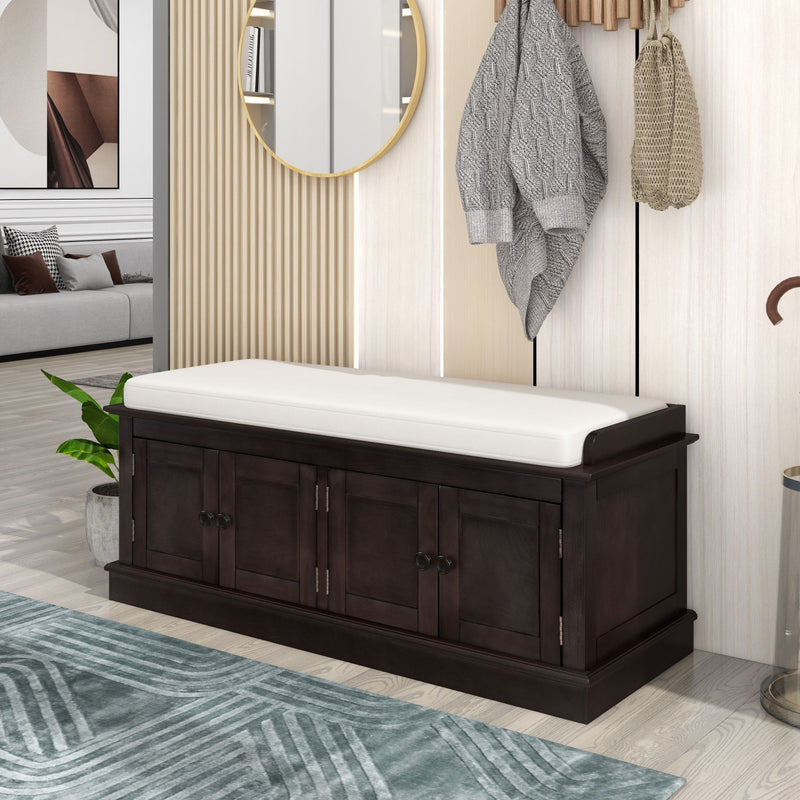 Dark brown shoe bench with a white cushion and four storage doors