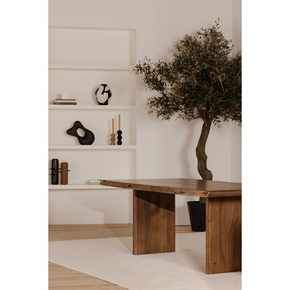 Large brown dining table with live-edge slab top and chunky block-style legs