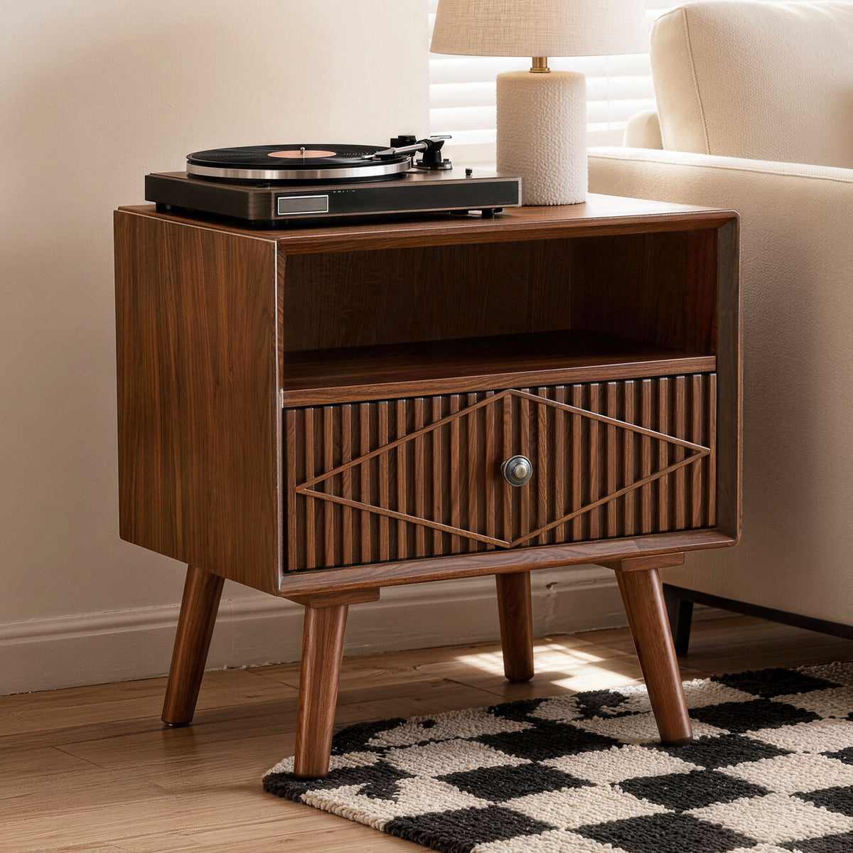 Walnut nightstand with one carved drawer and open shelf, shown with a turntable on top