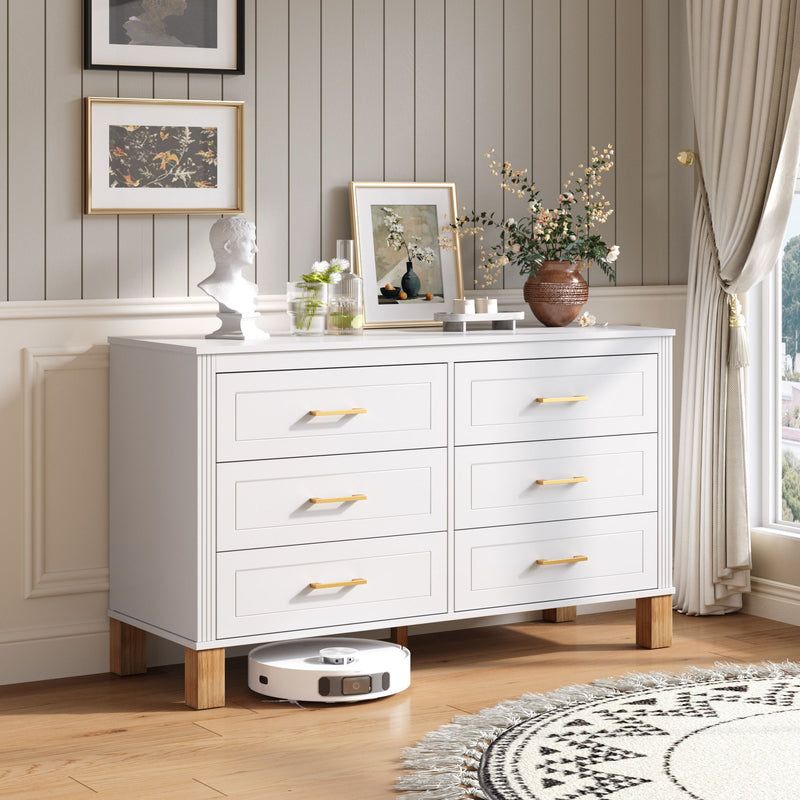 White double dresser with six drawers, gold-tone bar pulls, and wooden feet.