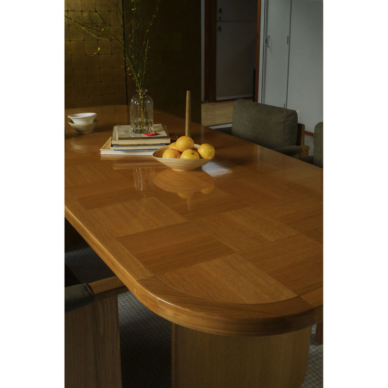 Light wood dining table with rounded edge apron and tapered legs