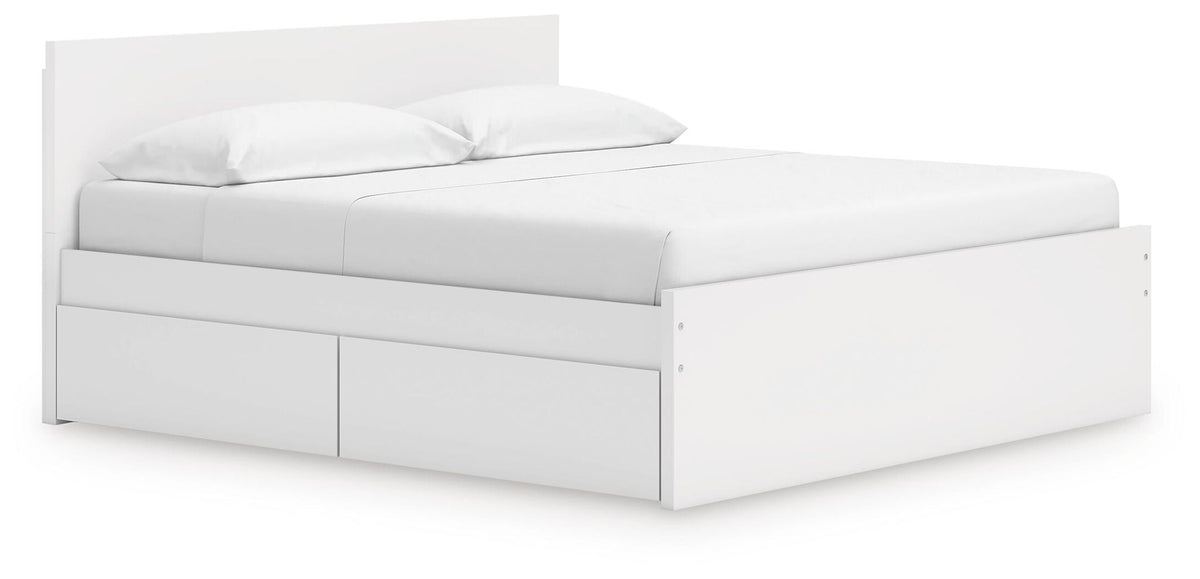 White platform bed with panel headboard and drawer storage, neatly styled bedding