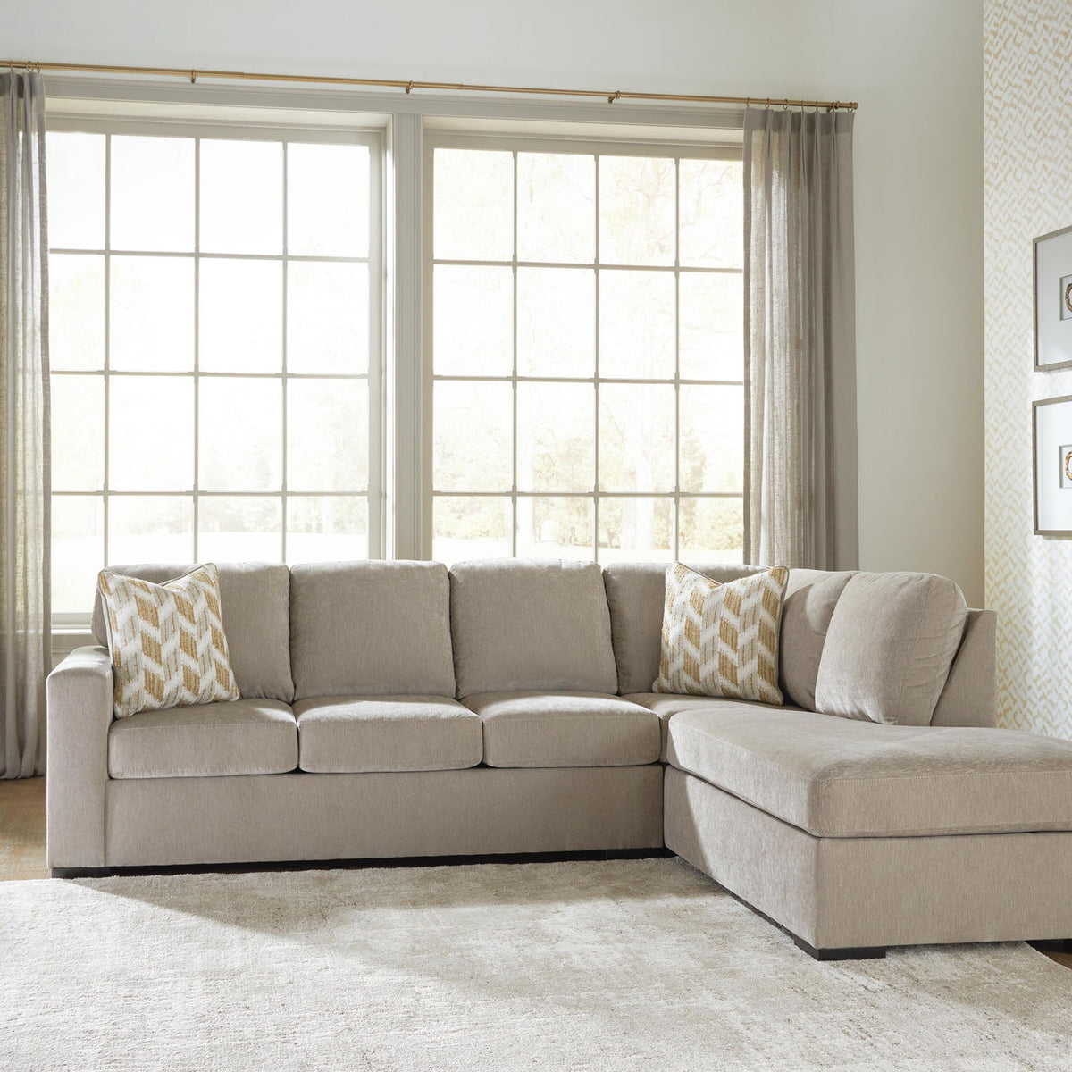 Beige corner chaise sectional sofa with multiple back cushions and patterned accent pillows.