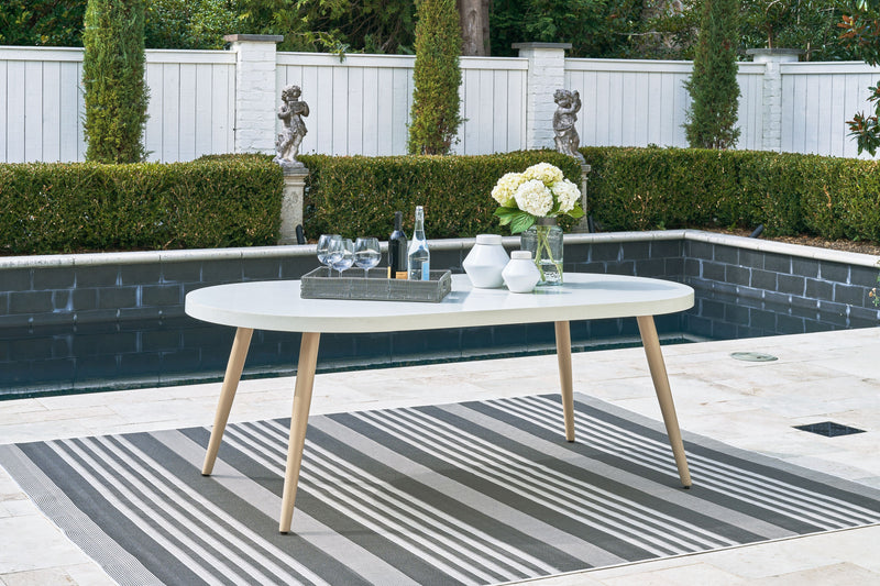 White oval outdoor dining table with four tapered legs