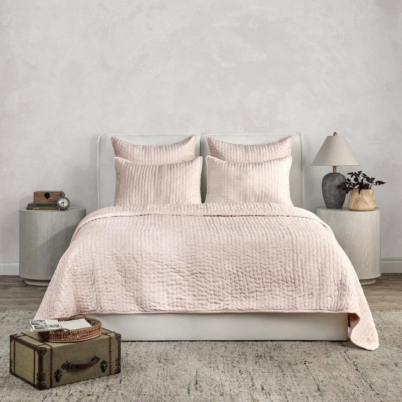Ivory velvet quilt set with textured quilt and matching shams on a bed