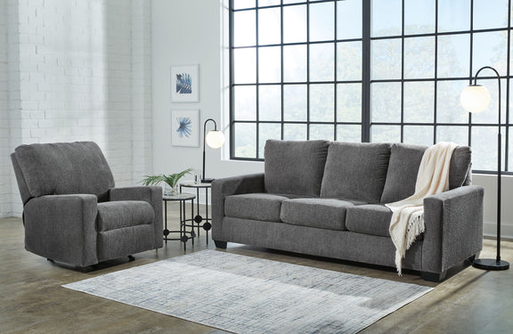 Dark gray sofa set with an extra armchair, square arms, and draped throw blanket