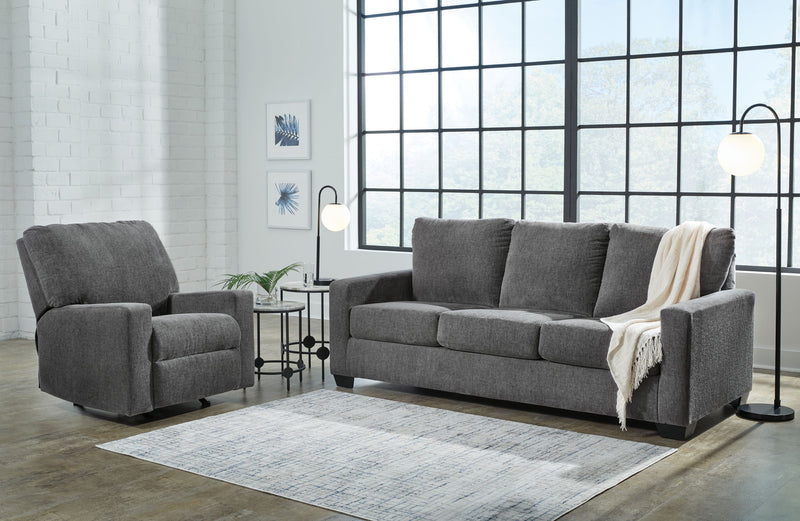 Dark gray sofa set with an extra armchair, square arms, and draped throw blanket