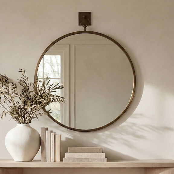 Wall-mounted round mirror with aged brass frame and back bracket