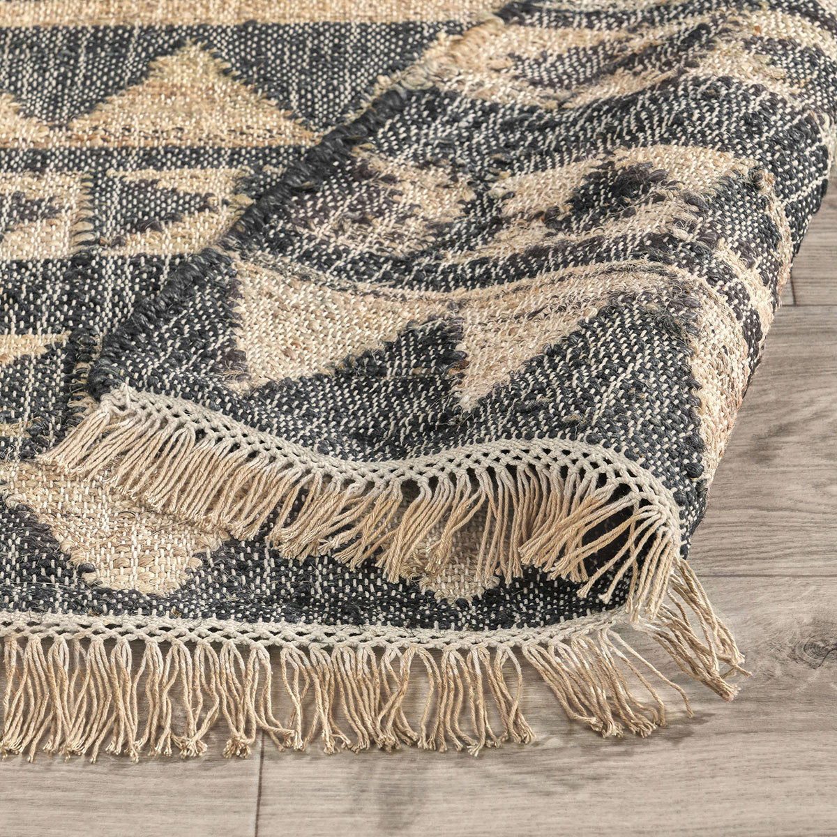 Solana rug in distressed black and natural with zigzag pattern and short fringe edge.
