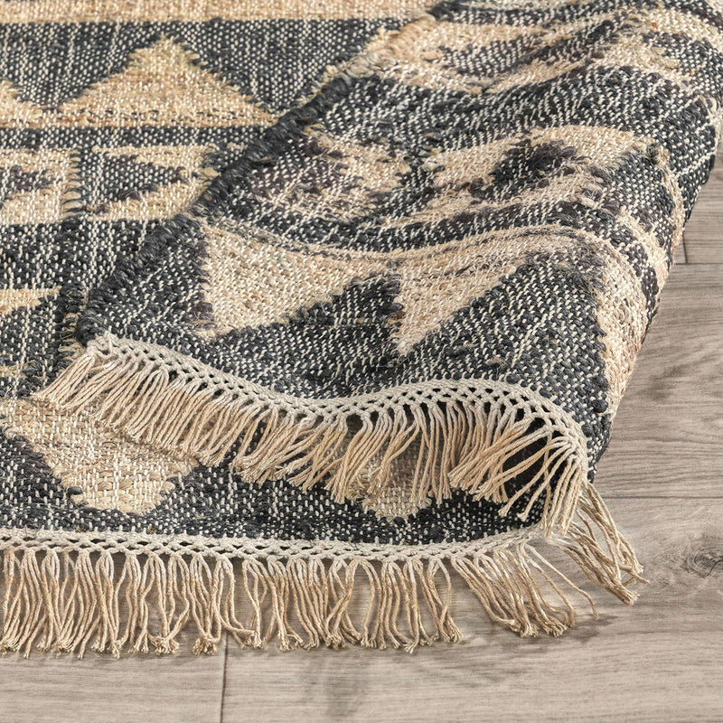 Solana rug in distressed black and natural with zigzag pattern and short fringe edge.
