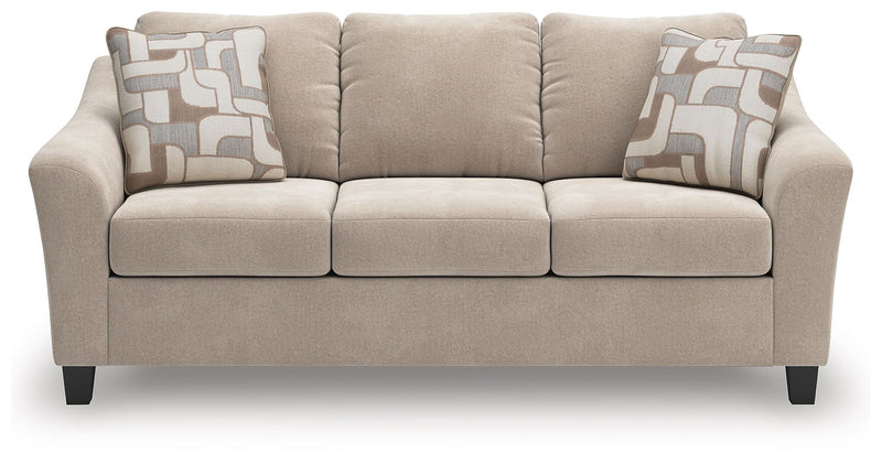 Taupe upholstered sofa with three seat cushions and two patterned throw pillows