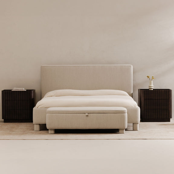 Light gray upholstered storage bench with hinged top and square button