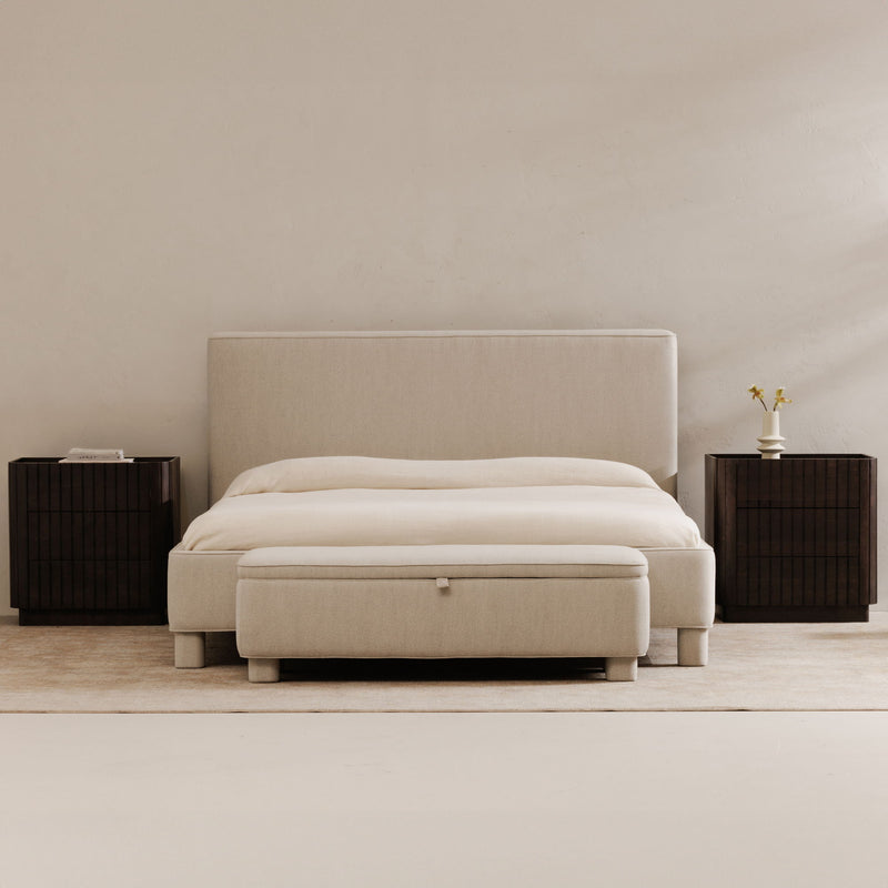 Light gray upholstered storage bench with hinged top and square button