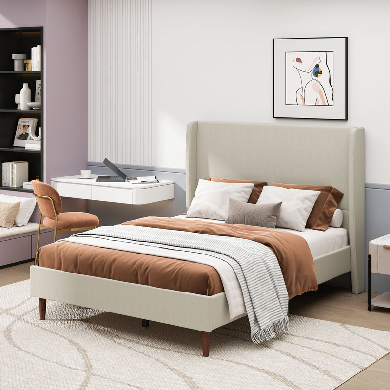 Beige upholstered bed with a tall headboard, wood legs, and bedding