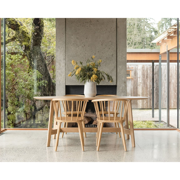 Small dining table, natural light oak, rounded tabletop with side apron and tapered legs.
