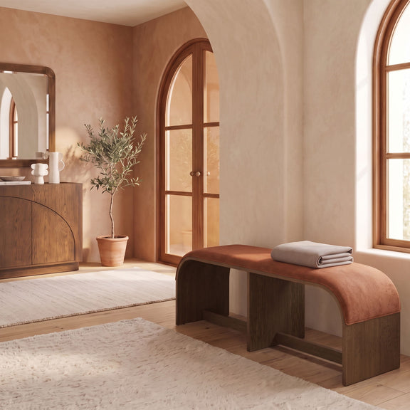 Velvet upholstered bench in warm brown with rounded seat corners in a living room