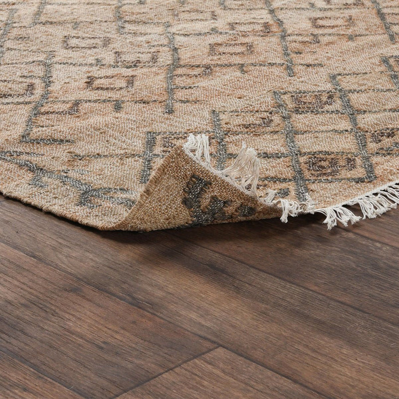 Rug corner detail: beige-and-sage geometric pattern with tassel fringe.