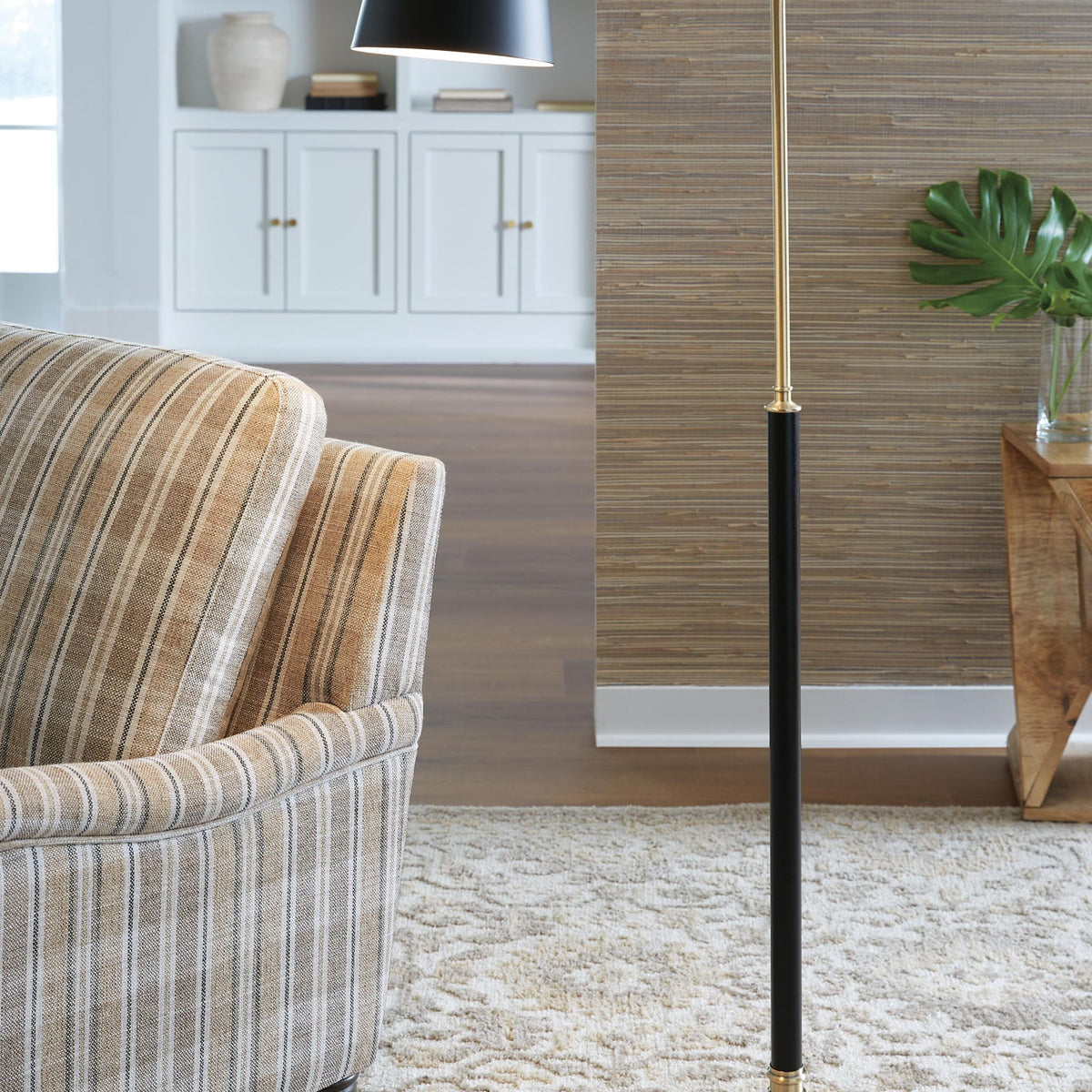 Metal floor lamp with black shade and brass-finish pole and round base
