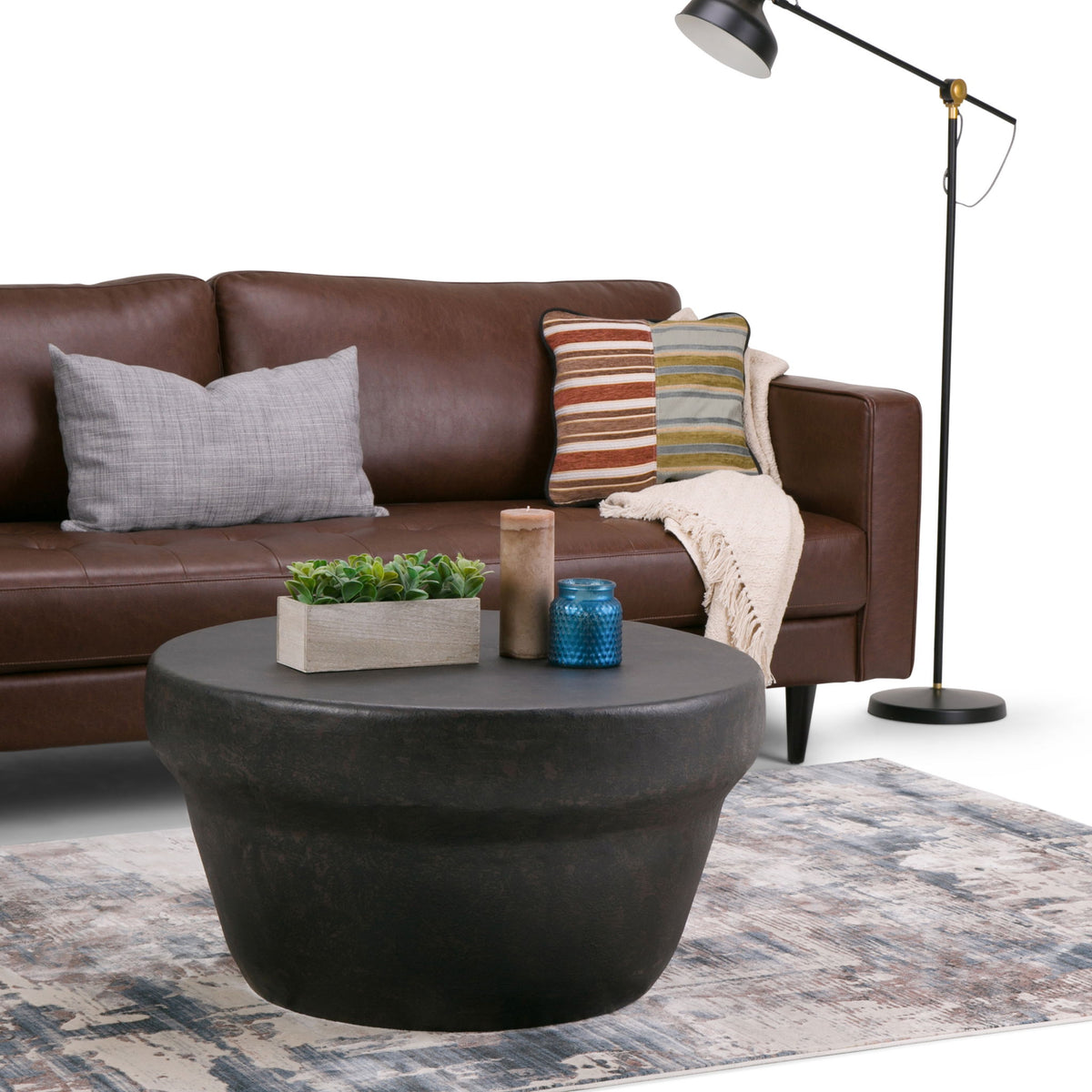 Round coffee table with rustic bronze finish and tapered shape