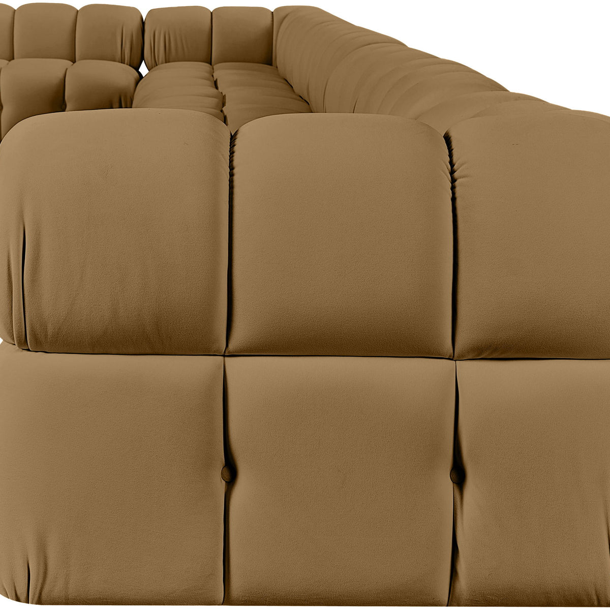L-shaped velvet sectional sofa in tan with large tufted cushions and rounded arm sections