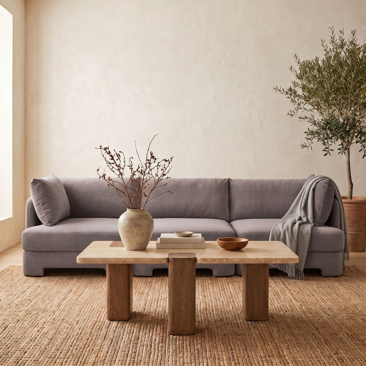 Gray upholstered 3-piece velvet sofa with back cushions and throw blanket draped