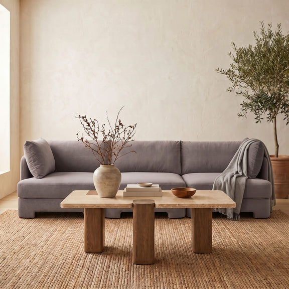Gray upholstered 3-piece velvet sofa with back cushions and throw blanket draped