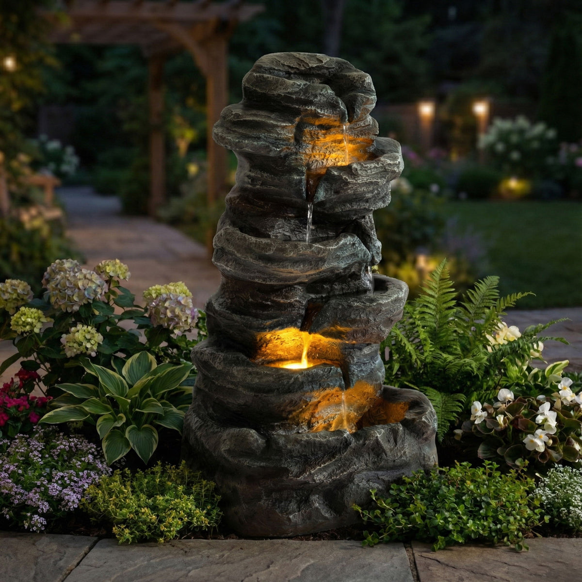 Gray tiered stone water fountain with warm LED-lit cascading streams