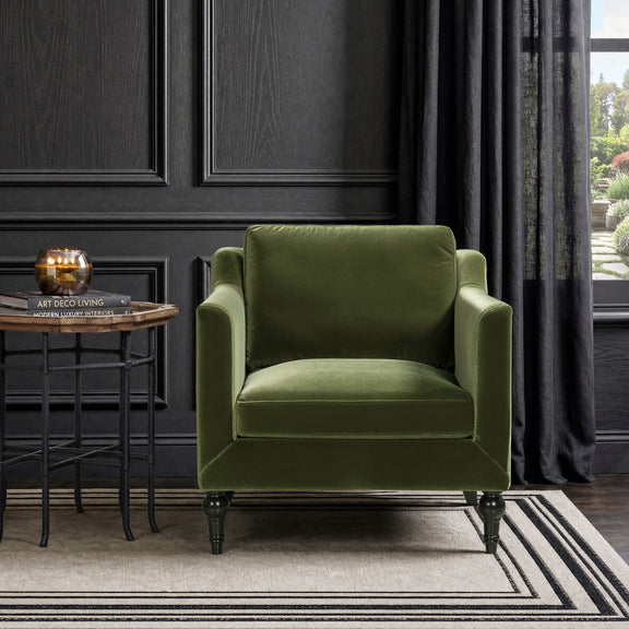 Green velvet-style upholstered accent chair with square arms and dark turned legs