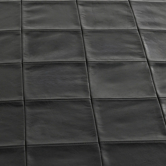 Close-up of dark leather bench seat with square stitched panels