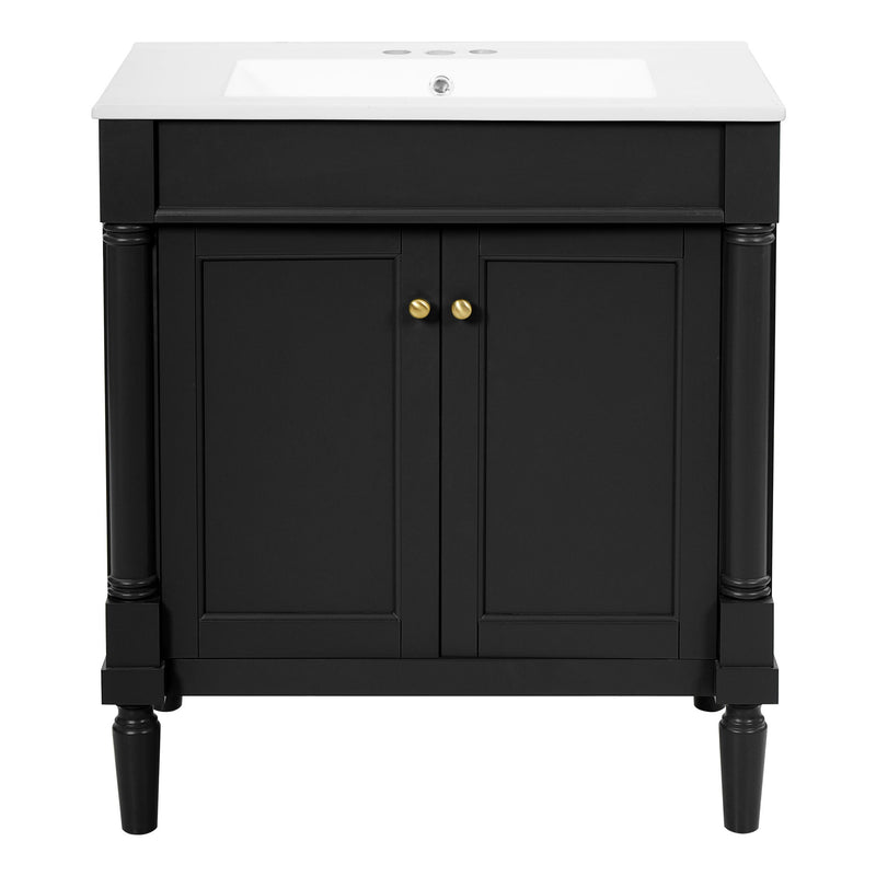 Black bathroom vanity cabinet with sink, two doors, gold knobs, pedestal legs