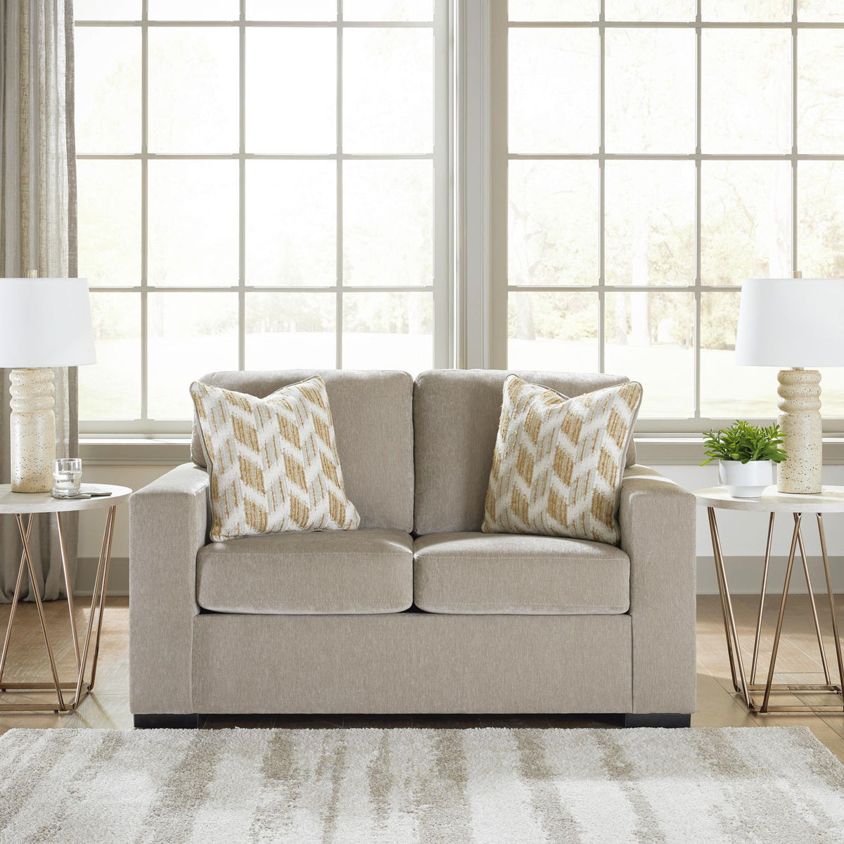 Beige loveseat with two patterned throw pillows and matching two-cushion seat